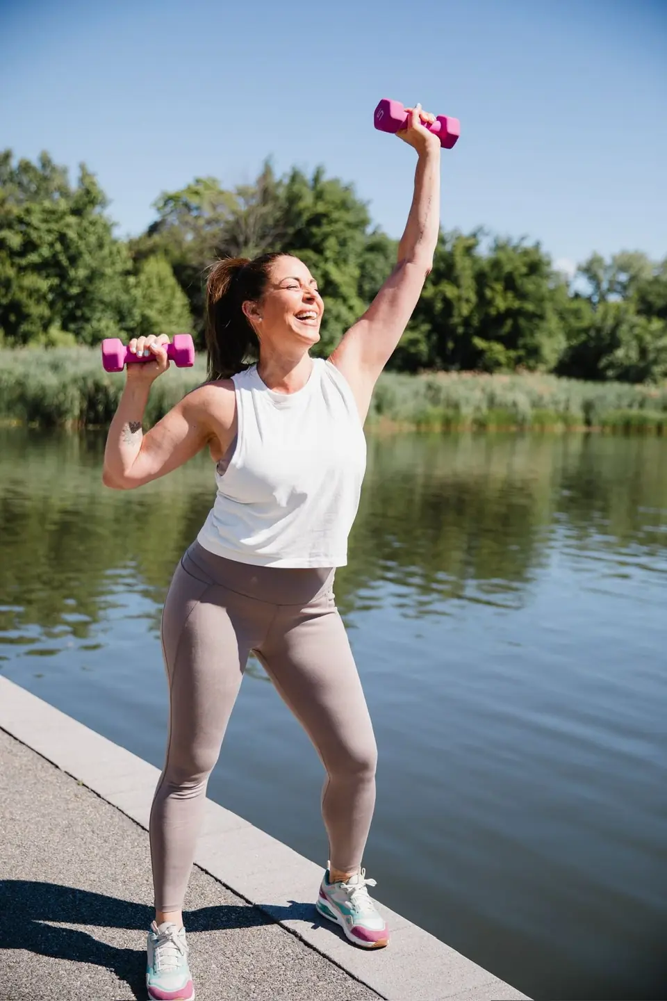 Jaly entrenando al aire libre con pesas junto a un lago